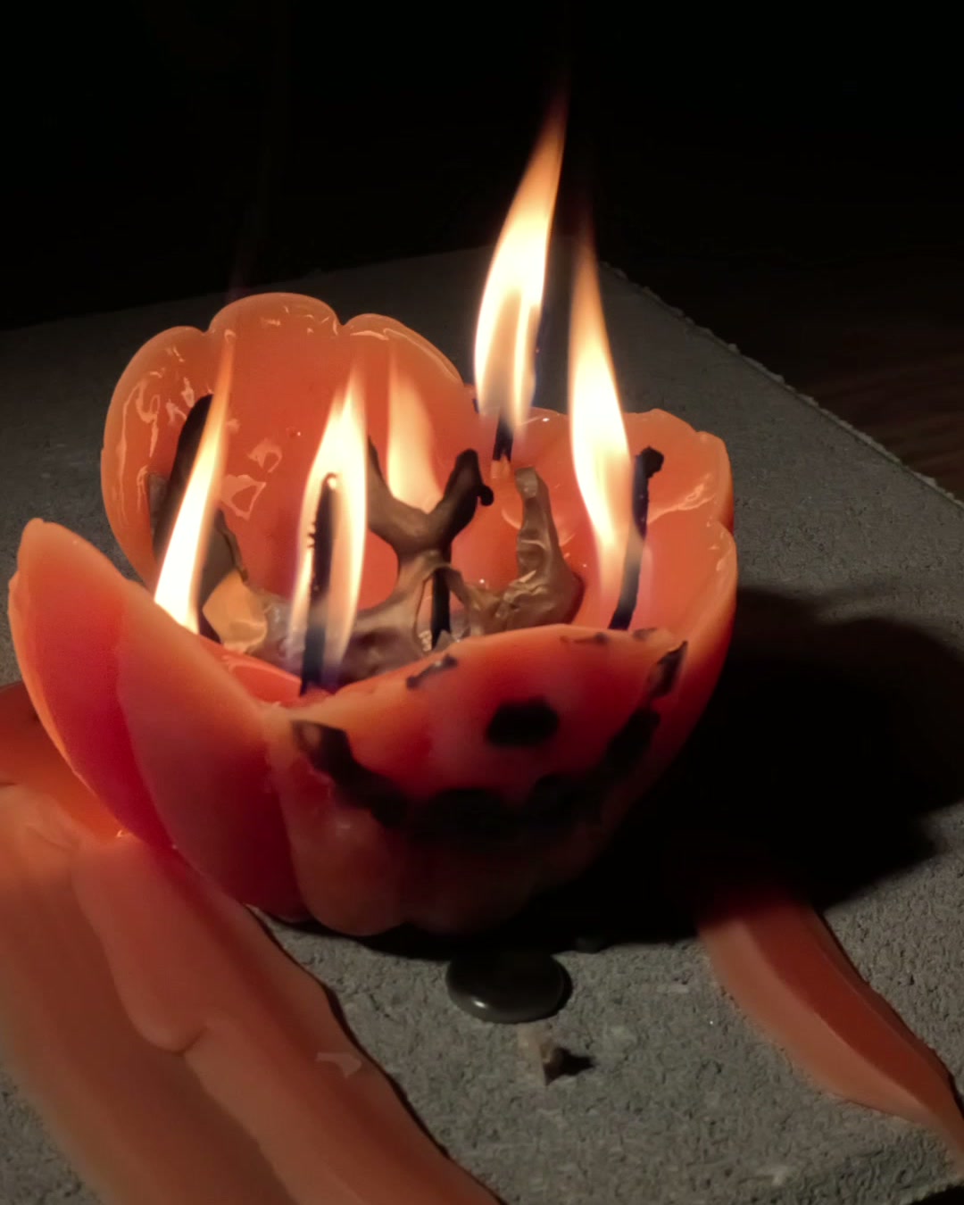 The wax pumpkin opening as it melts, skull emerging inside