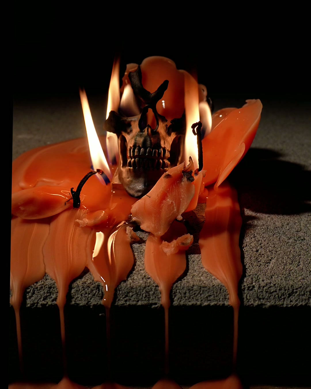 The skull standing in melted orange wax after the burn
